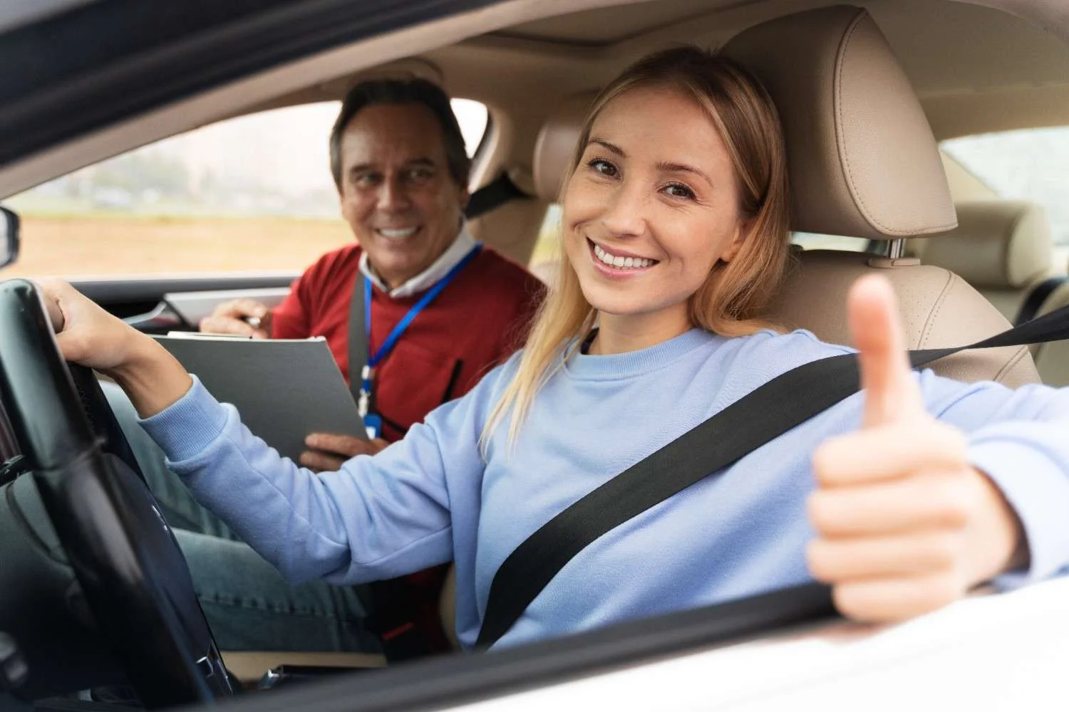 Driver smiling behind the wheel of her car